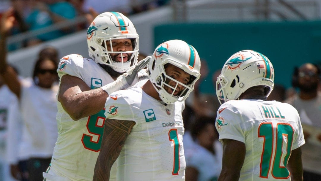 Miami Dolphins quarterback Tua Tagovailoa (1), Miami Dolphins wide receiver Tyreek Hill (10) and Miami Dolphins defensive tackle Christian Wilkins (94) celebrate Miami Dolphins running back De'Von Achane (not shown) scoring a touchdown during an NFL football game against the Denver Broncos, Sunday, Sept. 24, 2023, in Miami Gardens, Fla. (AP Photo/Doug Murray)