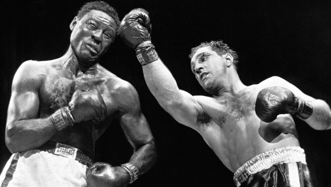 FILE - In this June 17, 1954 file photo, heavyweight champion Rocky Marciano strikes challenger Ezzard Charles with a right uppercut.