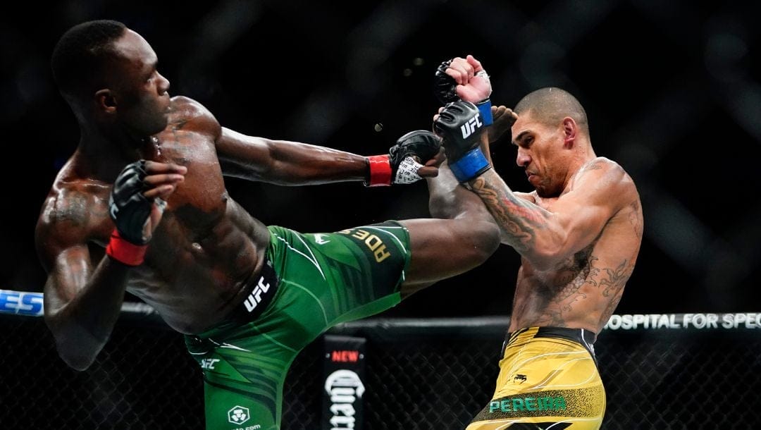 Brazil's Alex Pereira, right, blocks a kick by Nigeria's Israel Adesanya during the third round of a middleweight bout.