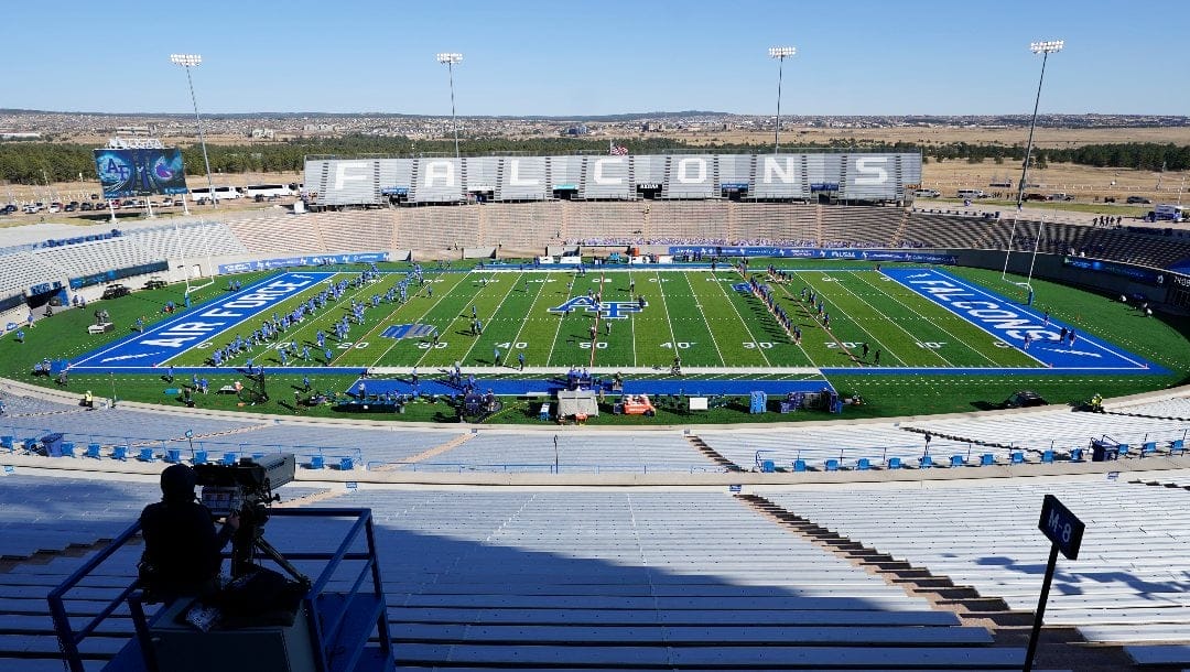 Air Force players, left, warm up with Boise State players in empty Falcon Stadium before an NCAA college football game Saturday Oct. 31 2020, at Air Force Academy, Colo.