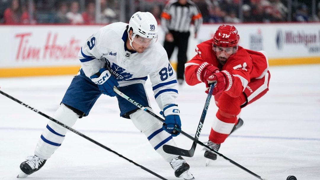 Detroit Red Wings center Dylan Larkin (71) lifts Toronto Maple Leafs left wing Nicholas Robertson (89) stick off the puck in the first period of an NHL preseason hockey game Saturday, Oct. 7, 2023, in Detroit.