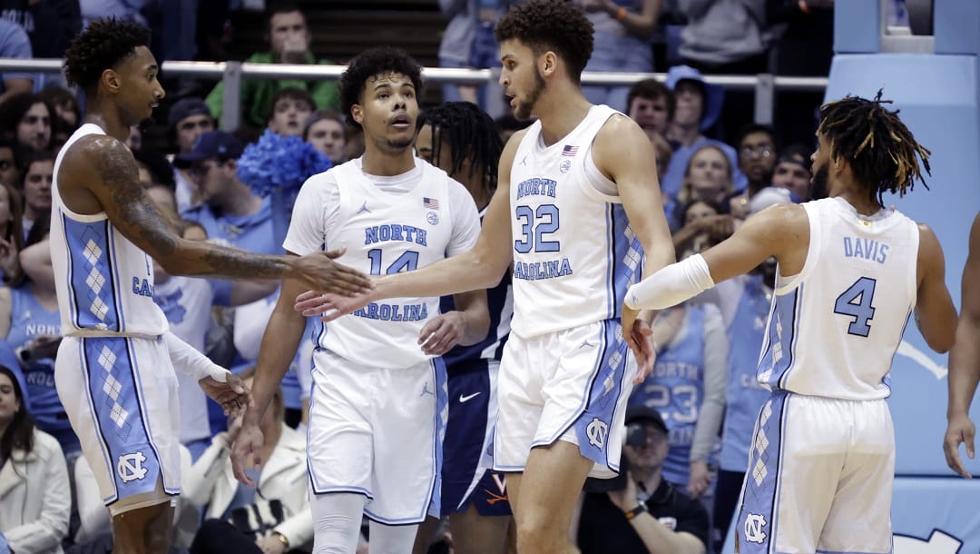 North Carolina forward Leaky Black, left, forward Puff Johnson (14) and guard R.J. Davis (4) congratulate forward Pete Nance (32) after he made a shot against Virginia during the second half of an NCAA college basketball game Saturday, Feb. 25, 2023, in Chapel Hill, N.C.