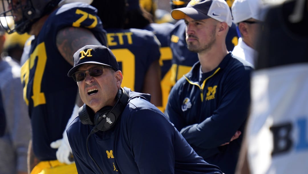 Michigan head coach Jim Harbaugh, front left, watches against Rutgers as analytics assistant Connor Stalions, right, looks on during an NCAA college football game in Ann Arbor, Mich., Sept. 23, 2023. Stalions was suspended by the university last week and is at the center of a sign-stealing scheme that is being investigated by the NCAA.