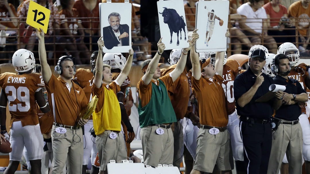 People hold up signs on Texas sidelines to call plays during the first quarter of an NCAA college football game against New Mexico, Saturday, Sept. 8, 2012, in Austin, Texas.