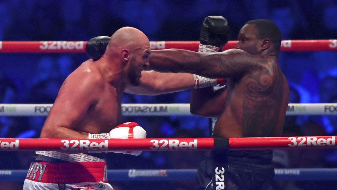 Britain's Tyson Fury, left, lands a blow on Britain's Dillian Whyte during their WBC heavyweight title boxing fight.