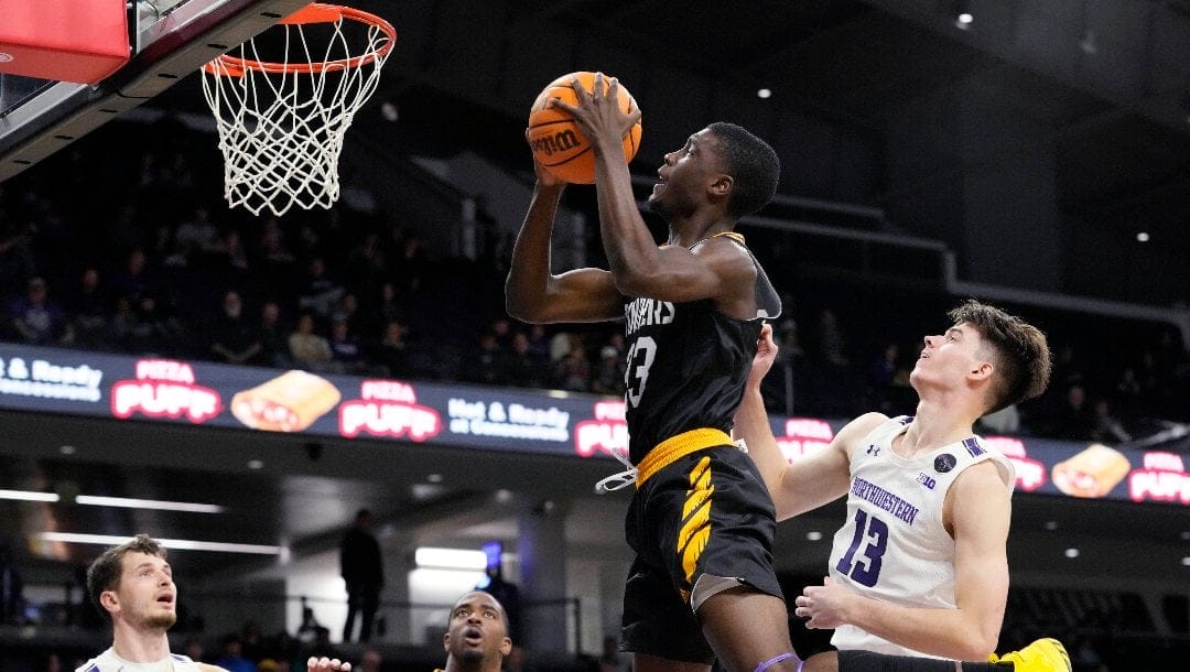 Prairie View A&M forward Mckinley Harris drives to the basket past Northwestern guard Brooks Barnhizer (13) during the first half of an NCAA college basketball game in Evanston, Ill., Sunday, Dec. 11, 2022. (AP Photo/Nam Y. Huh)