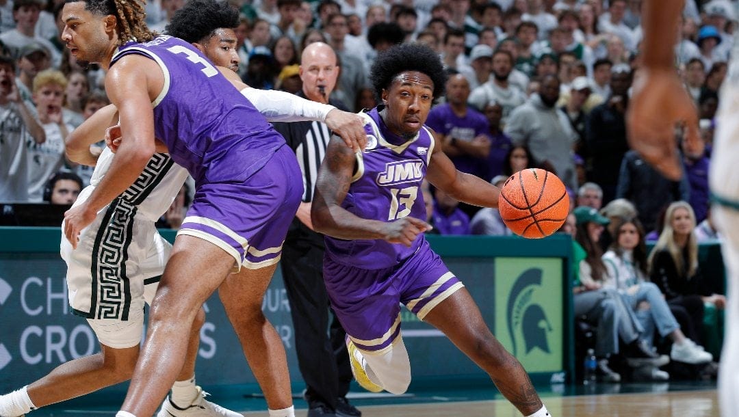 James Madison's Michael Green III, right, drives against Michigan State's Jaden Akins during an NCAA college basketball game, Monday, Nov. 6, 2023, in East Lansing, Mich.