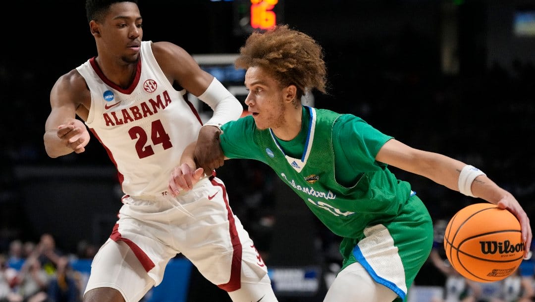 Texas A&M-Corpus Christi forward Owen Dease (12) dribbles past Alabama forward Brandon Miller (24) in the first half of a first-round college basketball game in the NCAA Tournament in Birmingham, Ala., Thursday, March 16, 2023. (AP Photo/Rogelio V. Solis)