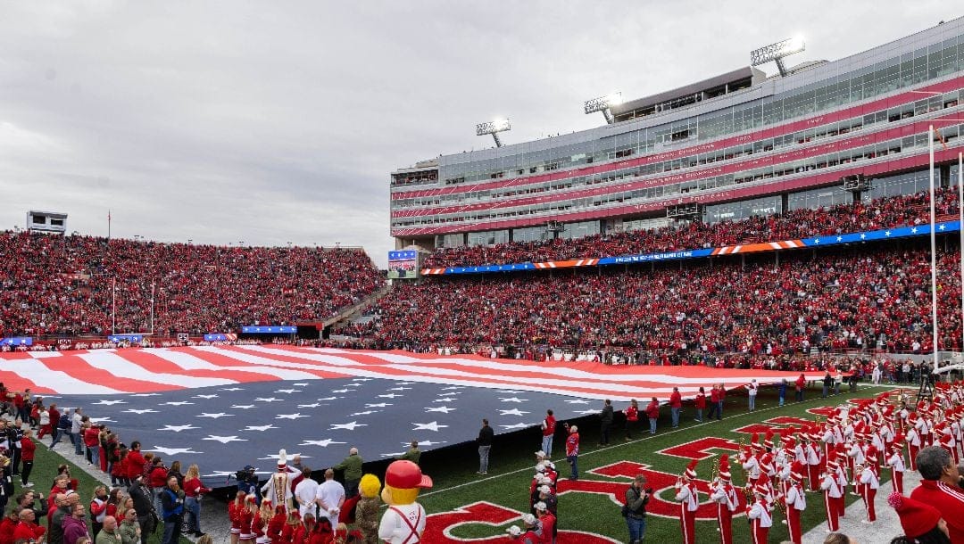 An American flag fills the field during the singing of the national anthem before Maryland and Nebraska play in an NCAA college football game Saturday, Nov. 11, 2023, in Lincoln, Neb.