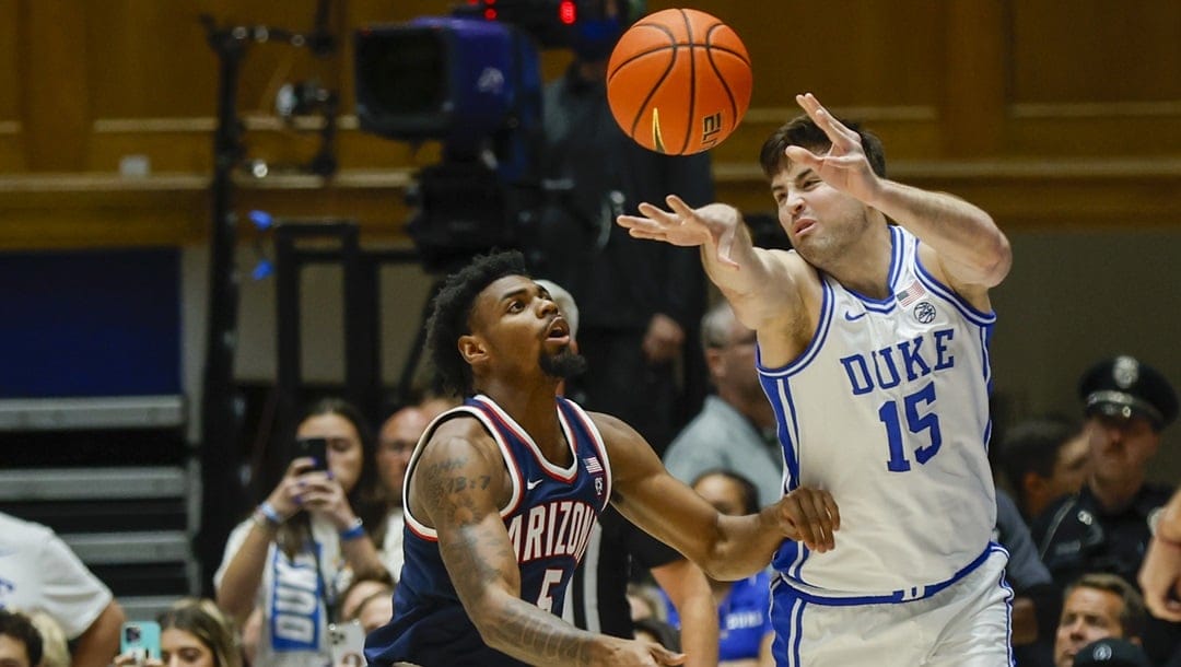 Duke center Ryan Young (15) passes the ball against Arizona guard KJ Lewis, left, during the first half of an NCAA college basketball game in Durham, N.C., Friday, Nov. 10, 2023.