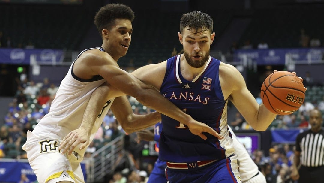 Kansas center Hunter Dickinson (1) tries to get past Marquette forward Oso Ighodaro (13) during an NCAA college basketball game, Tuesday, Nov. 21, 2023, in Honolulu.