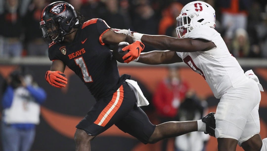 Oregon State running back Deshaun Fenwick (1) runs into the end zone to score a touchdown ahead of Stanford linebacker Gaethan Bernadel (0) during the second half of an NCAA college football game Saturday, Nov. 11, 2023, in Corvallis, Ore. Oregon State won 62-17.