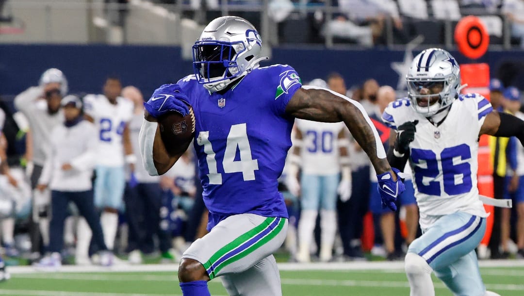 Seattle Seahawks wide receiver DK Metcalf (14) sprints to the end zone to score a touchdown after making a catch as Dallas Cowboys cornerback DaRon Bland (26) gives chase in the first half of an NFL football game in Arlington, Texas, Thursday, Nov. 30, 2023.