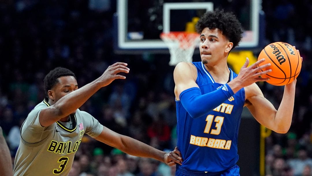 UC Santa Barbara guard Ajay Mitchell, right, looks to pass as Baylor guard Dale Bonner defends in the first half of a first-round college basketball game in the men's NCAA Tournament Friday, March 17, 2023, in Denver.