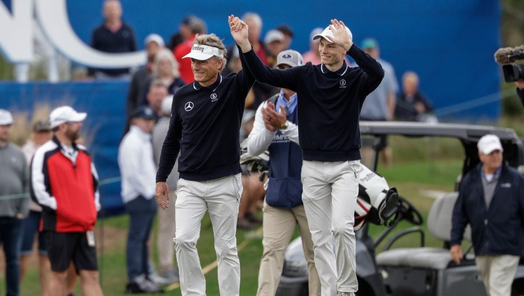 Bernhard Langer, left, and his son Jason, right, acknowledge the crowd on the 18th green during the final round of the PNC Championship golf tournament, Sunday, Dec. 17, 2023, in Orlando, Fla.
