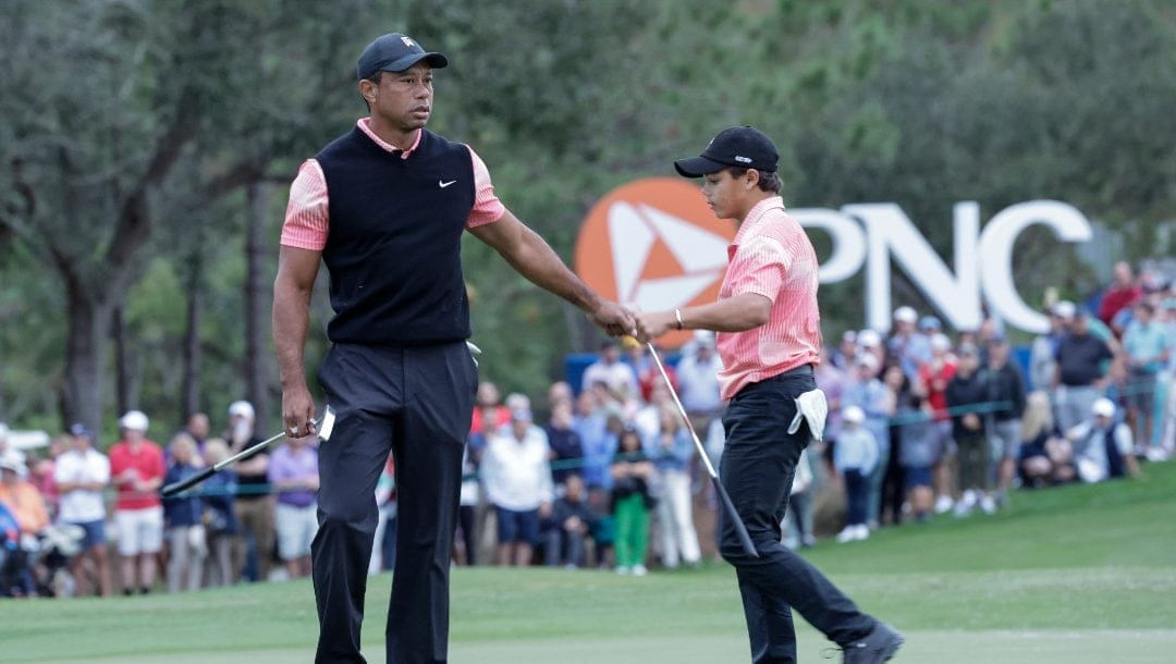 Tiger Woods, left, congratulates his son Charlie Woods, right, after finishing the 18th hole during the first round of the PNC Championship golf tournament Saturday, Dec. 17, 2022, in Orlando, Fla. Woods and his son are returning to play in this year's tournament for the fourth straight year.
