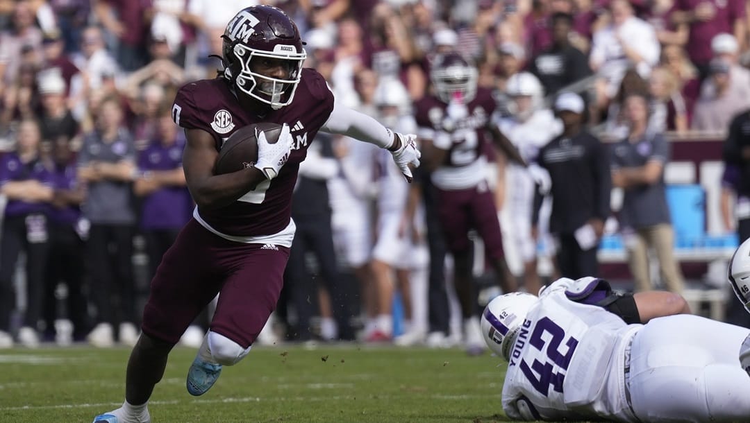 Texas A&M wide receiver Ainias Smith (0) breaks free from Abilene Christian defenders for a first down run after a catch during the first half of an NCAA college football game Saturday, Nov. 18, 2023, in College Station, Texas.