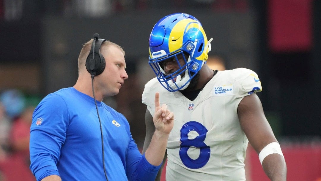 Los Angeles Rams linebackers coach Joe Coniglio talks to linebacker Jared Verse (8) during the first half of an NFL football game against the Arizona Cardinals, Sunday, Sept. 15, 2024, in Glendale, Ariz. (AP Photo/Rick Scuteri)