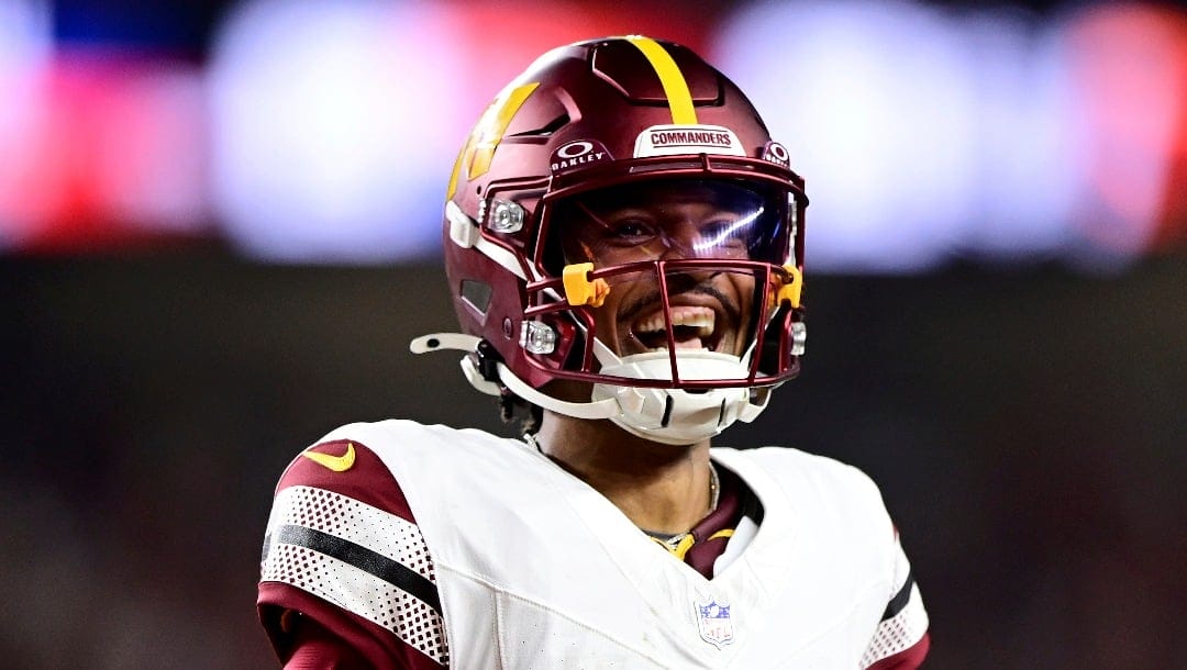 Washington Commanders quarterback Jayden Daniels (5) celebrates throwing a pass for a touchdown in the second half during an NFL football game against the Cincinnati Bengals on Monday, Sept. 23, 2024, in Cincinnati. (AP Photo/Emilee Chinn)