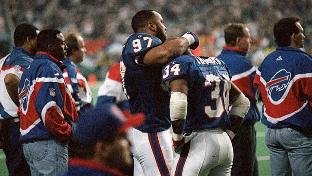 Buffalo Bills running back Thurman Thomas, (34) is comforted by teammate Cornelius Bennett, (97), on the sidelines after Thomas was stripped of the ball by Dallas Cowboys' Leon Lett during the third quarter of Super Bowl XXVIII, Jan. 30, 1994 in Atlanta. The fumble led to a Dallas touchdown.