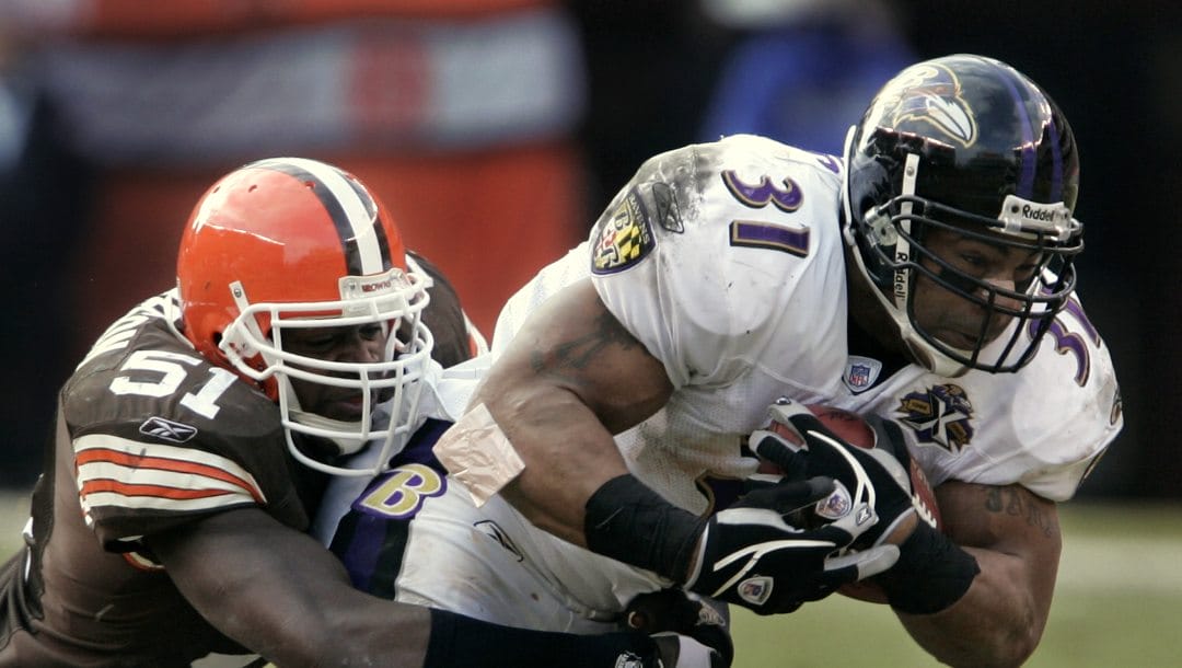 Baltimore Ravens runningback Jamal Lewis(31) stretches for yardage while in the grasp of Cleveland Browns linebacker Chaun Thompson in Cleveland, Ohio on Sunday, Jan. 1, 2006.