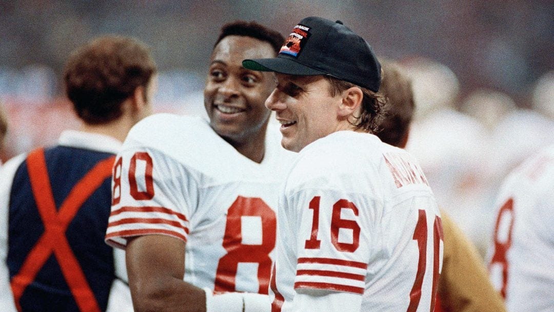 San Francisco 49ers quarterback Joe Montana (16) chats with wide receiver Jerry Rice late in Sunday, Jan. 29, 1990 Super Bowl thrashing of the Denver Broncos, 55-10. Rice caught three of Montana's five touchdown passes in the game at New Orleans.