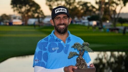 Matthieu Pavon holds the championship trophy on the South Course at Torrey Pines after winning the Farmers Insurance Open golf tournament, Saturday, Jan. 27, 2024, in San Diego.