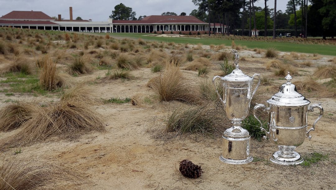 In this April 14, 2014, file photo, the men's and women's U.S. Open Championship trophies are displayed in a bunker along the 18th fairway at Pinehurst Resort & Country Club’s Course No. 2 in Pinehurst, N.C.