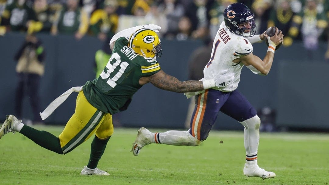Chicago Bears quarterback Justin Fields (1) scrambles around Green Bay Packers linebacker Preston Smith (91) during an NFL football game between the Green Bay Packers and Chicago Bears Sunday, Jan. 7, 2024, in Green Bay, Wis.