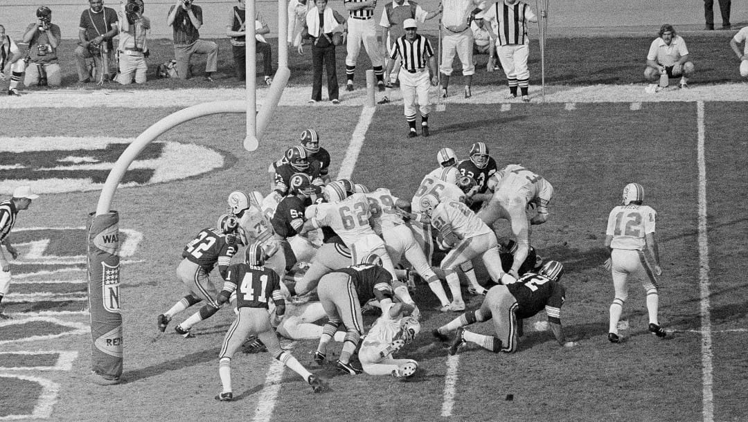 In this Jan. 14, 1973 file photo, Miami Dolphins' Jim Kiick (21) follows teammates Jim Langer (62) and Larry Csonka (39) to score against the Washington Redskins during Super Bowl VII in Los Angeles.
