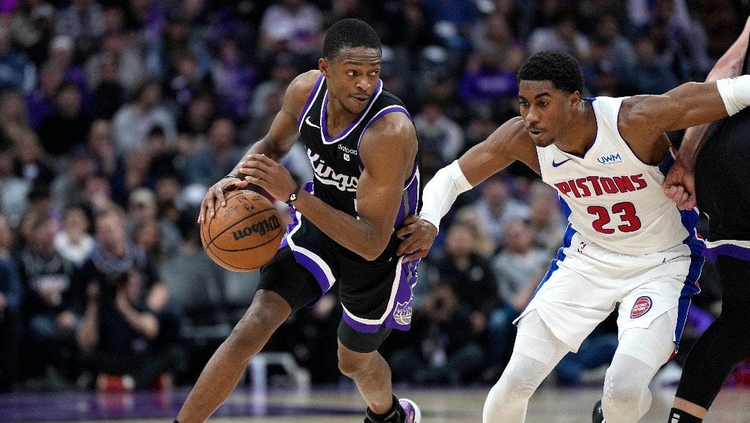 De'Aaron Fox #5 of the Sacramento Kings dribbling the ball guarded by Jaden Ivey #23 of the Detroit Pistons during the fourth quarter of an NBA basketball game at Golden 1 Center on February 07, 2024 in Sacramento, California.