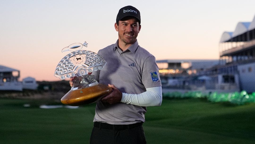 Nick Taylor, of Canada, poses with the trophy after winning the Phoenix Open golf tournament Sunday, Feb. 11, 2024, in Scottsdale, Ariz.