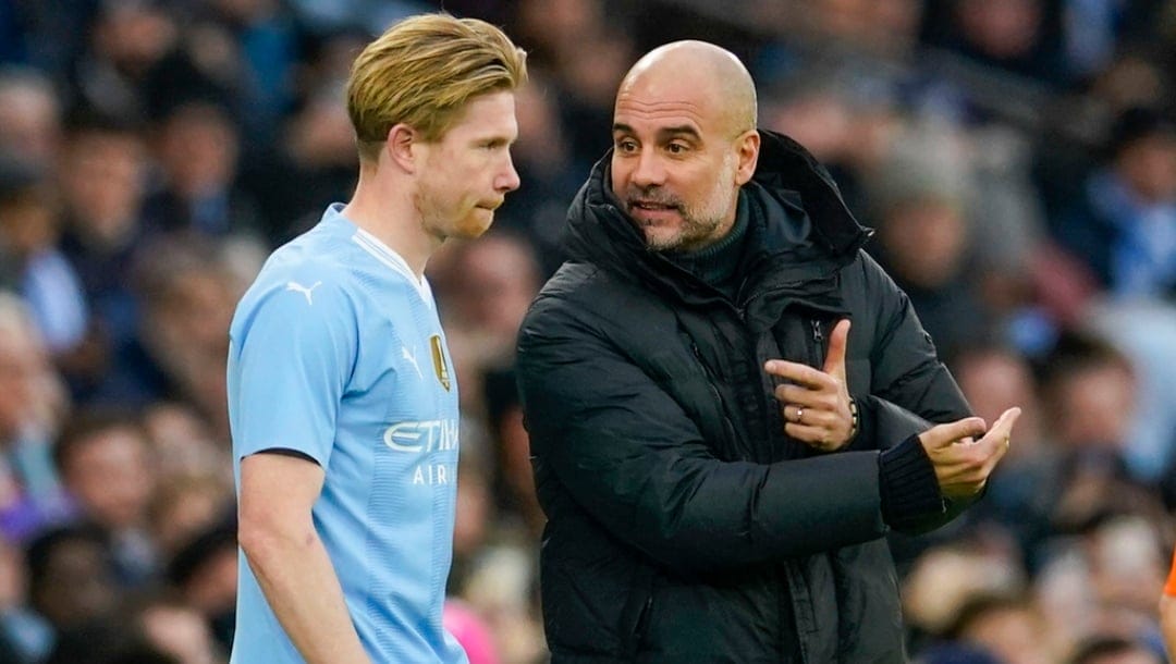 Manchester City's head coach Pep Guardiola, right, gives instructions to Manchester City's Kevin De Bruyne during the English FA Cup third round soccer match between Manchester City and Huddersfield Town, at the Etihad stadium in Manchester, England, Sunday, Jan. 7, 2024.