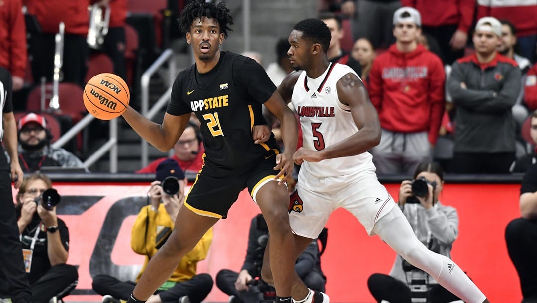 Appalachian State forward Justin Abson (21) looks for help from the defense of Louisville forward Brandon Huntley-Hatfield (5) during the second half of an NCAA college basketball game in Louisville, Ky., Tuesday, Nov. 15, 2022. Appalachian St. won 61-60.