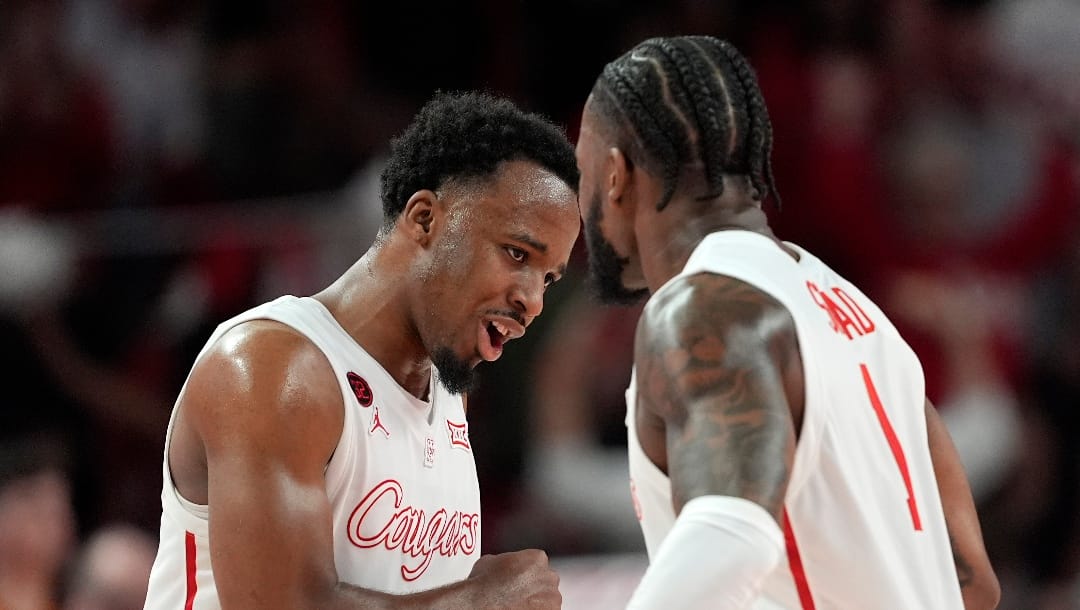 Houston's L.J. Cryer, celebrates with Jamal Shead after making a basket against Texas during the first half of an NCAA college basketball game Saturday, Feb. 17, 2024, in Houston. (AP Photo/David J. Phillip)