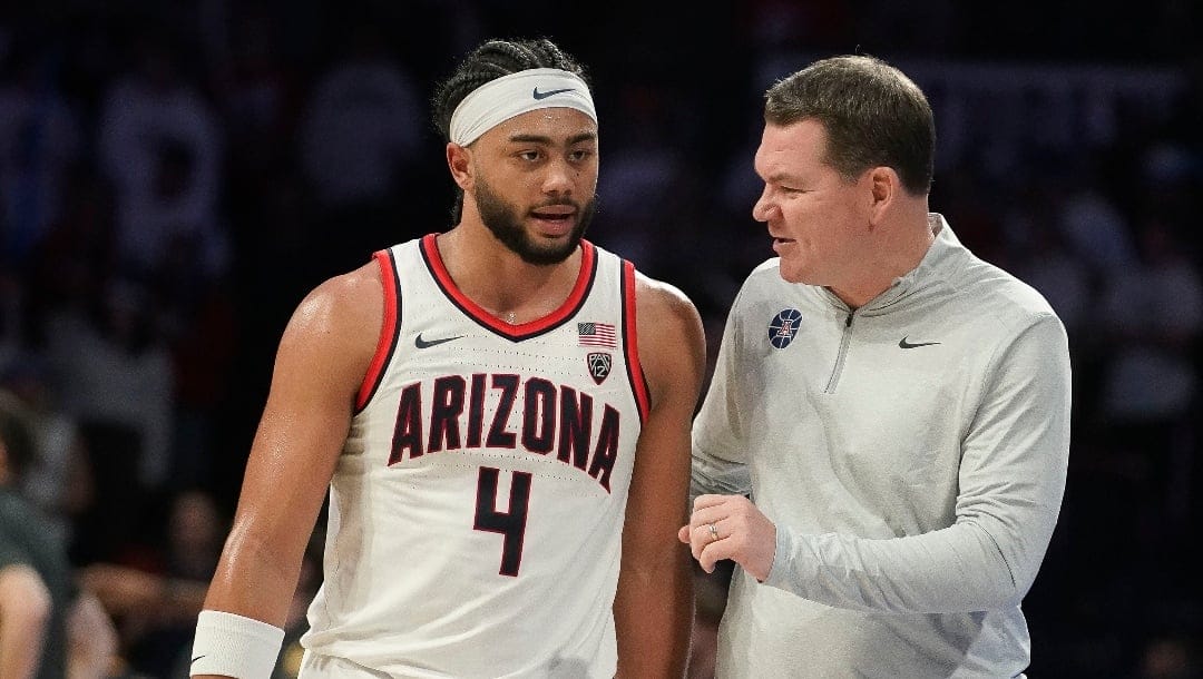 Arizona's head coach Tommy Lloyd right, talks with Kylan Boswell (4) during the second half of an NCAA college basketball game against California Thursday, Feb. 1, 2024, in Tucson, Ariz. (AP Photo/Darryl Webb)