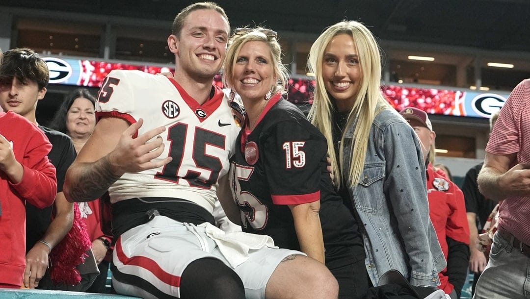 Georgia quarterback Carson Beck (15) sits with his mother Tracy, center, after the Orange Bowl NCAA college football game against Florida State, Saturday, Dec. 30, 2023, in Miami Gardens, Fla.