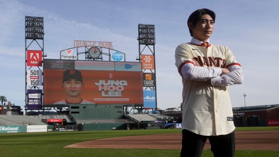 San Francisco Giants' Jung Hoo Lee poses for photos on the Oracle Park field after a baseball news conference in San Francisco, Friday, Dec. 15, 2023.