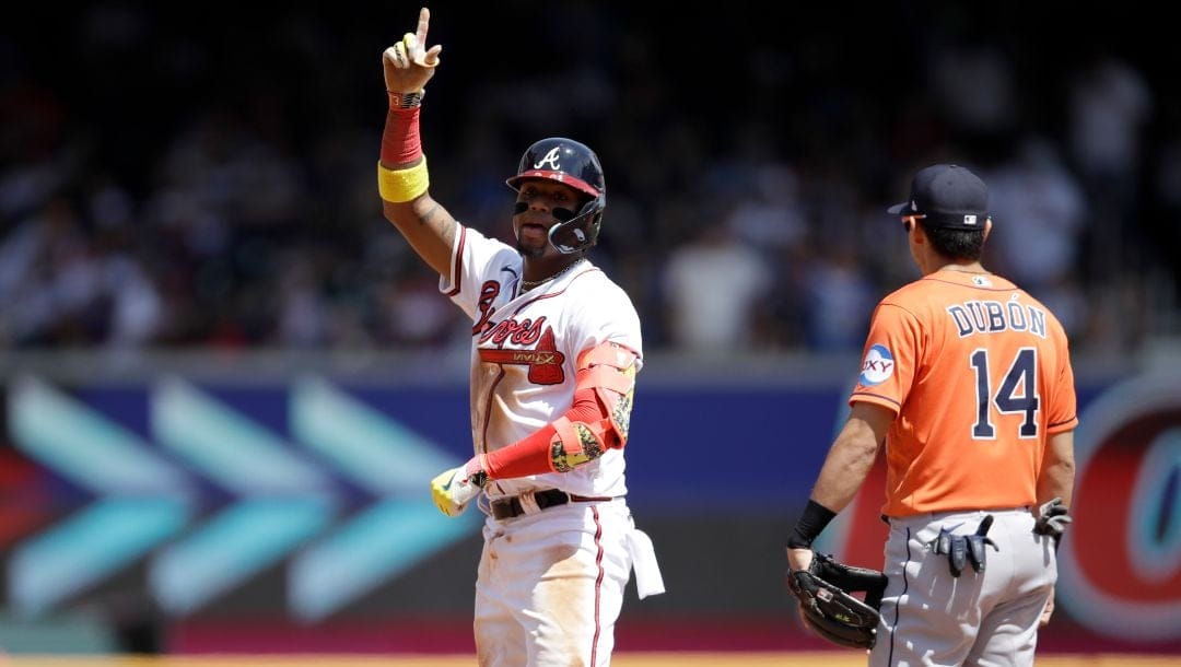 Atlanta Braves' Ronald Acuna Jr., left, celebrates beside Houston Astros' Mauricio Dubon (14) after hitting a double in the sixth inning of a baseball game, Sunday, April 23, 2023, in Atlanta.