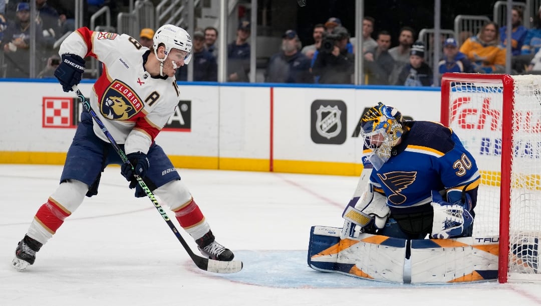 A shot by Florida Panthers' Matthew Tkachuk, left, bounces off St. Louis Blues goaltender Joel Hofer (30) during the first period of an NHL hockey game Tuesday, Jan. 9, 2024, in St. Louis. (AP Photo/Jeff Roberson)