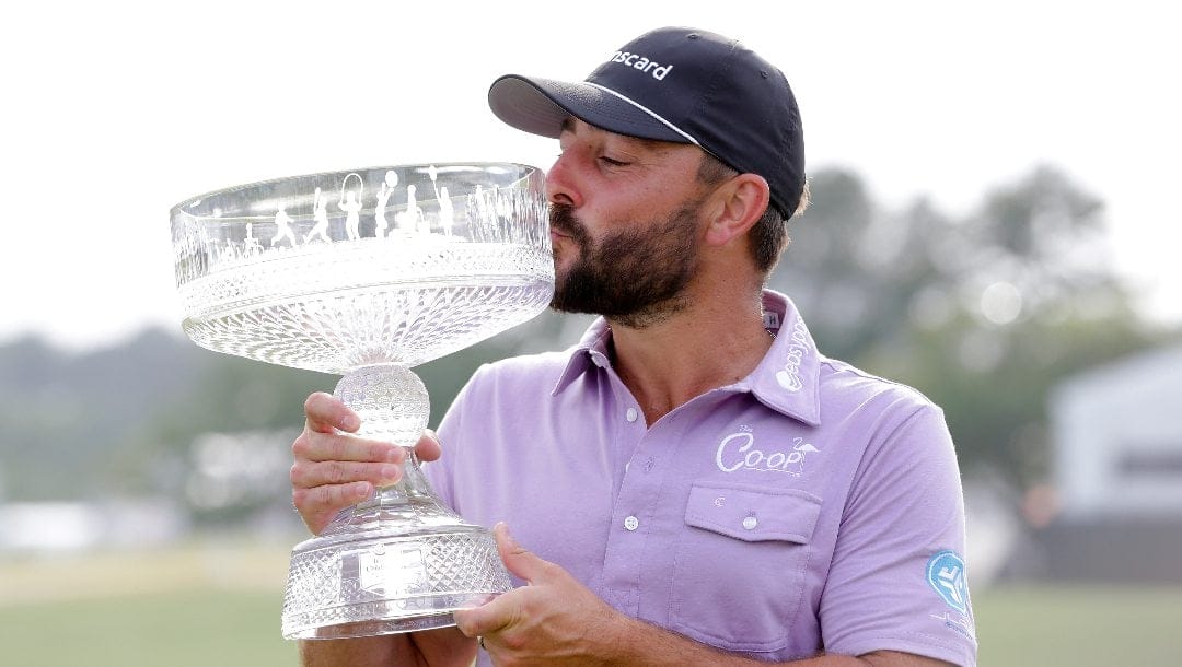 Stephan Jaeger kisses the trophy as he poses for photos during ceremonies after his win in the final round of the Houston Open golf tournament Sunday, March 31, 2024, in Houston.
