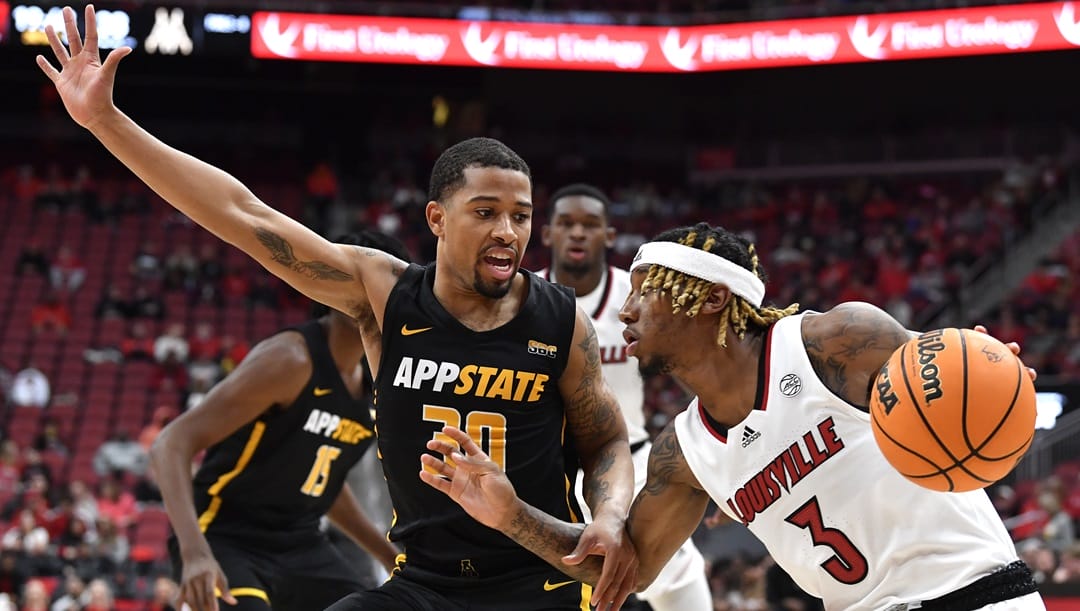 Louisville guard El Ellis (3) attempts to get past Appalachian State guard Tyree Boykin (30) during the second half of an NCAA college basketball game in Louisville, Ky., Tuesday, Nov. 15, 2022.