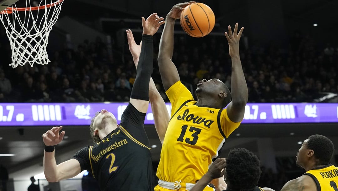 Iowa forward Ladji Dembele(13) rebounds a ball against Northwestern forward Nick Martinelli during the first half of an NCAA college basketball game in Evanston, Ill., Saturday, March 2, 2024.