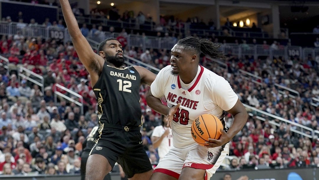 North Carolina State's DJ Burns, Jr. (30) drives against Oakland's Tuburu Naivalurua (12) during the first half of a college basketball game in the second round of the NCAA men's tournament Saturday, March 23, 2024, in Pittsburgh.