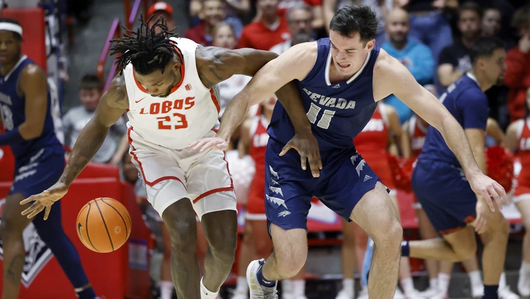 New Mexico center Nelly Junior Joseph, left, and Nevada forward Nick Davidson chase a loose ball during the first half of an NCAA basketball game, Sunday, Jan. 28, 2024, in Albuquerque, N.M.