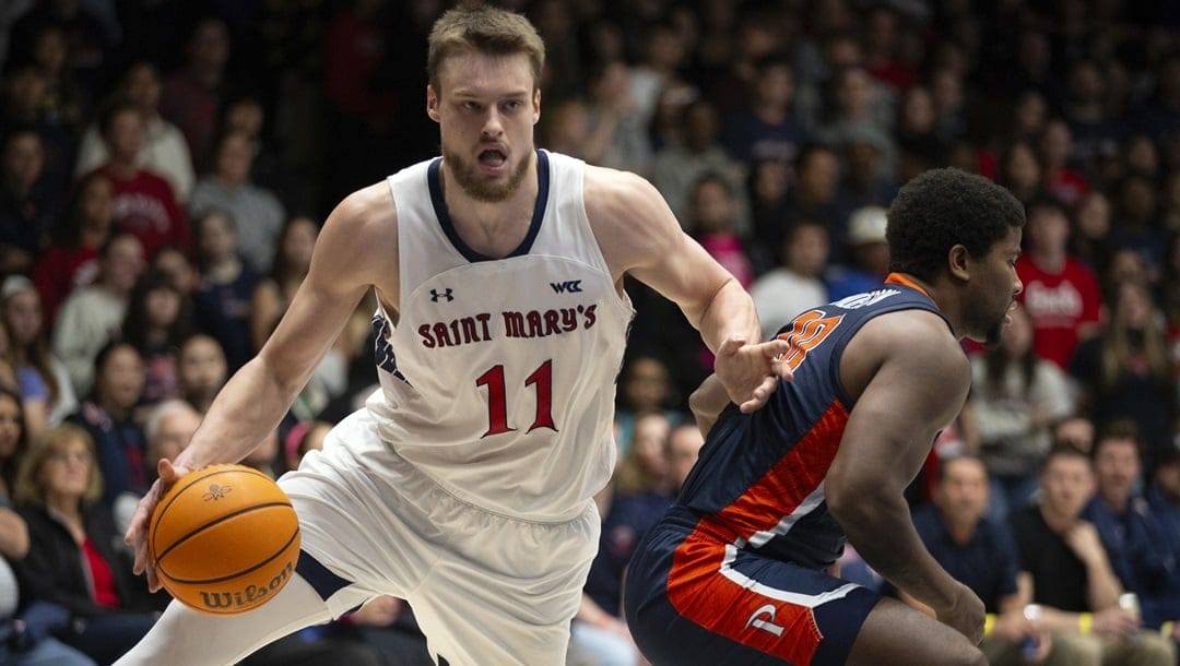 Saint Mary's center Mitchell Saxen (11) drives behind Pepperdine guard Ethan Anderson (20) during the first half of an NCAA college basketball game, Thursday, Feb. 15, 2024, in Moraga, Calif.