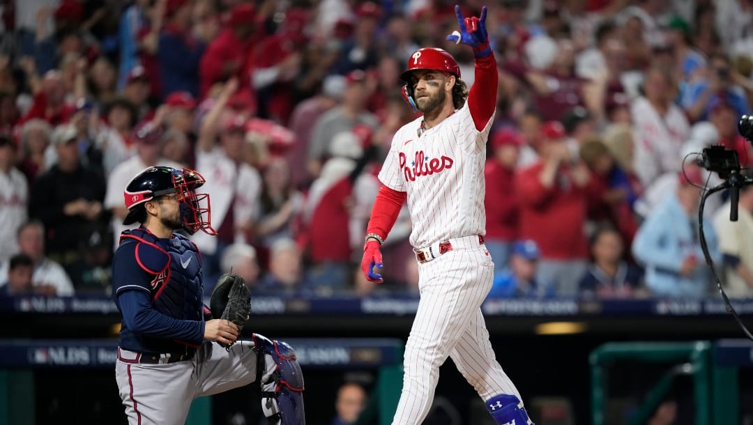 Philadelphia Phillies' Bryce Harper reacts after hitting a home run during the fifth inning of Game 3 of a baseball NL Division Series against the Atlanta Braves in Philadelphia.