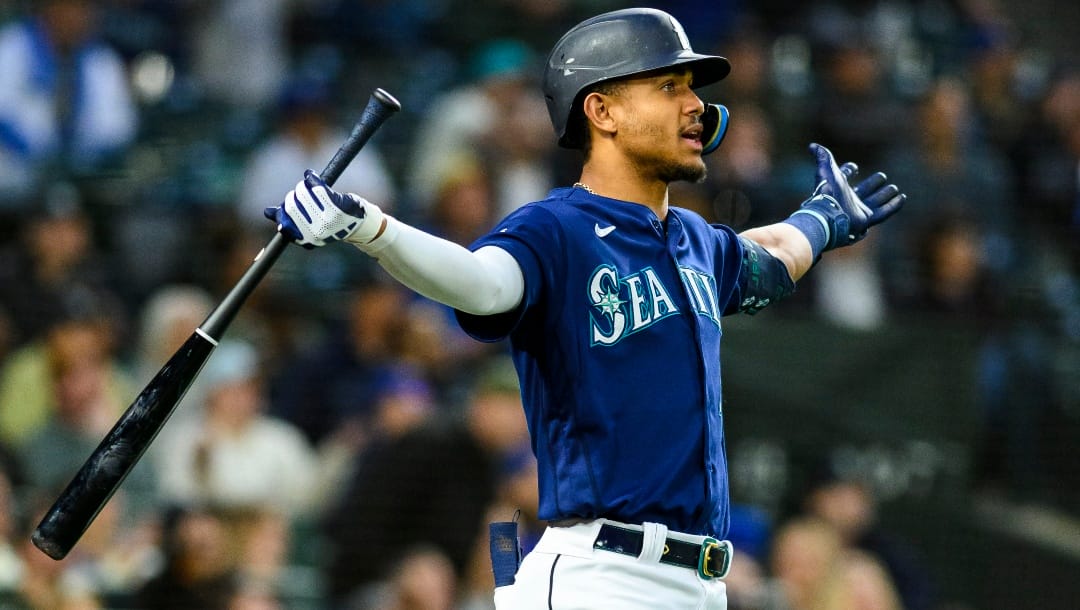 Seattle Mariners' Julio Rodriguez reacts after the umpires confirmed a challenged call, ruling him out for fan interference on a foul ball during the eighth inning of the team's baseball game against the Oakland Athletics, Tuesday, May 23, 2023, in Seattle.