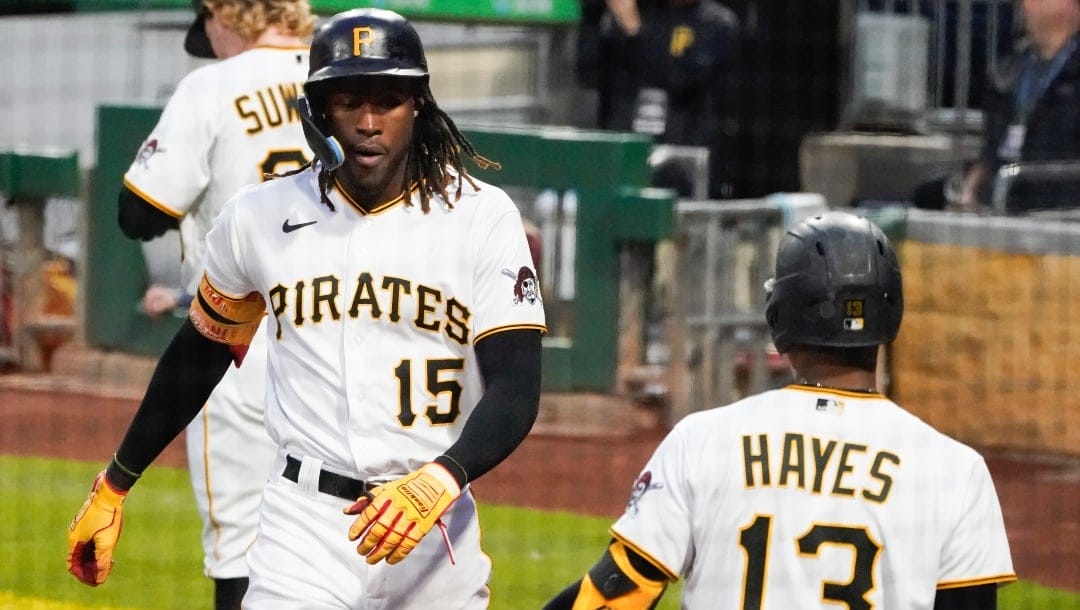 Pittsburgh Pirates' Oneil Cruz (15) is greeted by Ke'Bryan Hayes (13) after scoring from third on a ground ball by of a baseball game, Tuesday, Oct. 4, 2022, in Pittsburgh.