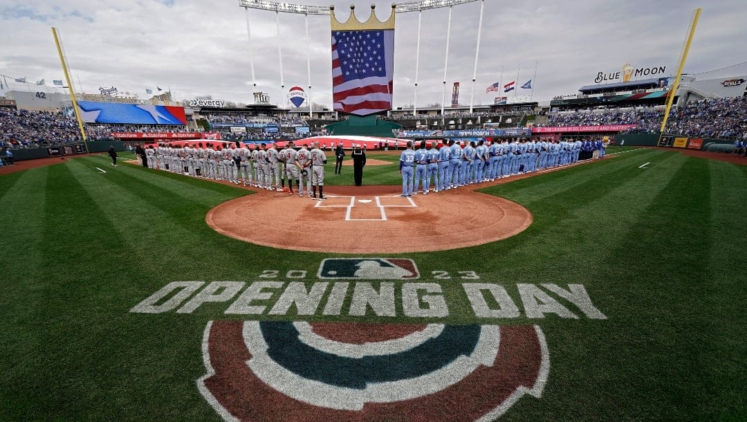 FILE - Players stand for the national anthem before an opening day baseball game between the Kansas City Royals and the Minnesota Twins in Kansas City, Mo., on March 30, 2023. An annual study reviewing diversity hiring for Major League Baseball on Thursday, June 15, reported a record low of Black players on opening-day rosters for the second straight year.